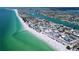 Expansive coastal aerial view with turquoise waters, white sand beaches and a vibrant neighborhood at 7532 Bayshore Dr # 205, Treasure Island, FL 33706