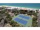 Aerial view showcasing condo buildings and tennis courts near the beach and ocean at 7532 Bayshore Dr # 205, Treasure Island, FL 33706