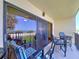 View from the lanai of the ocean, beach, palm trees, blue sky, and table with chairs at 7532 Bayshore Dr # 205, Treasure Island, FL 33706