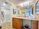 Bright bathroom features a vanity with an oversized mirror and shower at 7532 Bayshore Dr # 205, Treasure Island, FL 33706