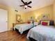 Bedroom boasts two twin beds, ceiling fan, wood laminate flooring and a wicker dresser at 7532 Bayshore Dr # 205, Treasure Island, FL 33706