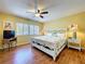 Bright bedroom featuring a ceiling fan, decorative white frame bed, side tables, and laminate wood floors at 7532 Bayshore Dr # 205, Treasure Island, FL 33706