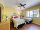 Bedroom boasts two twin beds, ceiling fan, wood laminate flooring and a wicker dresser at 7532 Bayshore Dr # 205, Treasure Island, FL 33706