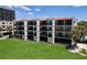 Well-maintained condo building featuring private balconies and a lush green lawn at 7532 Bayshore Dr # 205, Treasure Island, FL 33706