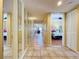 Long hallway with mirrored walls, tiled floors, and a view into the bedroom at 7532 Bayshore Dr # 205, Treasure Island, FL 33706