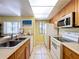 Bright kitchen with stainless steel microwave, tile floors, and a pass-through to the living area at 7532 Bayshore Dr # 205, Treasure Island, FL 33706