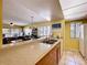Open-concept kitchen with stainless steel sink, breakfast bar, and a view into the living area at 7532 Bayshore Dr # 205, Treasure Island, FL 33706