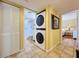 Laundry room featuring stackable washer/dryer with tile floors with access to bathroom and bedroom at 7532 Bayshore Dr # 205, Treasure Island, FL 33706