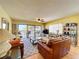 Bright living room with leather couches, ceiling fan, and sliding glass doors leading to a private balcony at 7532 Bayshore Dr # 205, Treasure Island, FL 33706