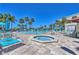 Beautiful condo complex with multiple pools, jacuzzi, lounge chairs, and tropical landscaping at 7532 Bayshore Dr # 205, Treasure Island, FL 33706