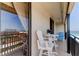 Peaceful balcony featuring white chairs, a table, and partial ocean view at 3820 Gulf Blvd # 608, St Pete Beach, FL 33706