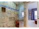 Shower with glass enclosure and stone tile at 3820 Gulf Blvd # 608, St Pete Beach, FL 33706