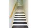 Modern staircase with a wooden handrail and dark brown steps at 1919 21St S St, St Petersburg, FL 33712