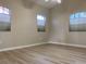 Bright bedroom with light wood flooring and two arched windows at 2733 Mcnair Dr, Palm Harbor, FL 34683