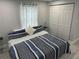 Comfortable bedroom with a striped bedspread, gray walls, white curtains, and closet at 4438 58Th N Ave, St Petersburg, FL 33714