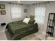 This bedroom features an inviting green bed set, complemented by sheer floral curtains for natural light at 4438 58Th N Ave, St Petersburg, FL 33714