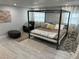 Modern bedroom features a four-poster bed, light grey walls, wood floors, sheer curtains, and neutral accents at 4438 58Th N Ave, St Petersburg, FL 33714