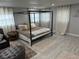 Modern bedroom features a four-poster bed, light grey walls, wood floors, sheer curtains, and neutral accents at 4438 58Th N Ave, St Petersburg, FL 33714