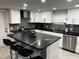 Modern kitchen featuring white cabinets, stainless steel appliances, a large island, and sleek black countertops at 4438 58Th N Ave, St Petersburg, FL 33714