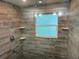 Modern shower featuring wood-look tile walls, a rain shower head, and built-in shelving for added convenience at 4438 58Th N Ave, St Petersburg, FL 33714
