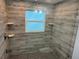 Modern shower featuring wood-look tile walls, a rain shower head, and built-in shelving for added convenience at 4438 58Th N Ave, St Petersburg, FL 33714