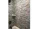 Close-up of shower featuring decorative horizontal tiles and a built-in shelf with bathroom essentials at 4438 58Th N Ave, St Petersburg, FL 33714