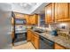 Well-equipped kitchen featuring granite countertops and wood cabinets at 800 Madonna Blvd # B, Tierra Verde, FL 33715