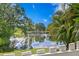 Serene pond view with lush greenery and white fence at 10823 Indian Hills Ct # 33, Seminole, FL 33777