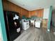 A galley kitchen with wood cabinets, appliances, and laminate flooring at 15529 Redington Dr, Redington Beach, FL 33708