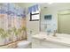 Cozy bathroom featuring beach themed shower curtain, white vanity, and neutral wall color at 1354 Azalea Dr # 1803, Dunedin, FL 34698
