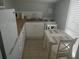 Small galley kitchen with white cabinets and modern appliances at 18 Heilwood St, Clearwater Beach, FL 33767