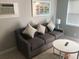 Living room with gray sofa and round coffee table at 18 Heilwood St, Clearwater Beach, FL 33767