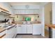 White kitchen with full-size appliances and a view into living room at 1354 Azalea Dr # 1803, Dunedin, FL 34698