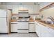 Updated kitchen with white cabinets and an electric range at 1354 Azalea Dr # 1803, Dunedin, FL 34698