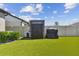 Artificial turf backyard with storage shed and grilling station at 9309 Rally Spring Loop, Wesley Chapel, FL 33545