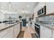 Modern kitchen with granite countertops, white cabinets, and teal island seating at 9309 Rally Spring Loop, Wesley Chapel, FL 33545