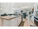Modern kitchen with granite countertops, white cabinets, and teal island seating at 9309 Rally Spring Loop, Wesley Chapel, FL 33545