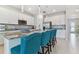 Modern kitchen with granite countertops, white cabinets, and teal island seating at 9309 Rally Spring Loop, Wesley Chapel, FL 33545