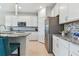 Modern kitchen with granite countertops, white cabinets, and teal island seating at 9309 Rally Spring Loop, Wesley Chapel, FL 33545