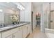 Elegant bathroom with double vanity, granite countertop and walk-in shower at 9309 Rally Spring Loop, Wesley Chapel, FL 33545