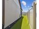 Landscaped side yard with artificial turf and privacy fence at 9309 Rally Spring Loop, Wesley Chapel, FL 33545