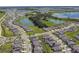 Aerial view of a beautiful community with a lake and lush greenery at 9309 Rally Spring Loop, Wesley Chapel, FL 33545