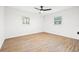 Simple bedroom featuring wood flooring, two windows, and a ceiling fan at 508 Brooker Rd, Brandon, FL 33511