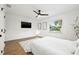 Bright bedroom featuring wood flooring, a TV, and white colored decor at 508 Brooker Rd, Brandon, FL 33511