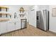Modern kitchen featuring a farmhouse sink, stainless steel appliances, open shelving, and wood-look floors at 508 Brooker Rd, Brandon, FL 33511