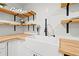 Close-up of a farmhouse-style kitchen sink with white cabinets, wooden countertops and open shelving at 508 Brooker Rd, Brandon, FL 33511