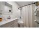 Clean bathroom with a white vanity, marble countertop and patterned shower curtain at 6199 59Th N Pl, St Petersburg, FL 33709