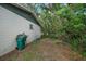 Side yard with a green waste bin and gardening tools at 6199 59Th N Pl, St Petersburg, FL 33709