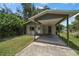 Front view of a house with a carport and a grassy yard at 6199 59Th N Pl, St Petersburg, FL 33709
