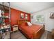 Main bedroom with orange accent wall and wooden bed frame at 6199 59Th N Pl, St Petersburg, FL 33709